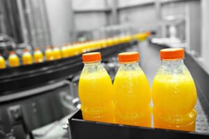 Orange juice bottles on factory assembly line